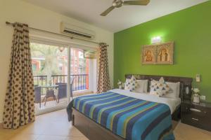 巴加Heritage Exotica Villa - 4BHK, Baga的一间卧室设有绿色的墙壁、一张床和窗户