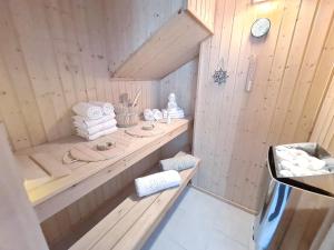 巴贝Strandhaus Rügen - Sauna, Kamin, Whirlpool的一个带木柜台和毛巾的桑拿浴室