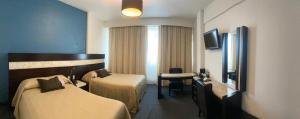 莱昂Hotel Real Rex的酒店客房配有两张床和一张书桌