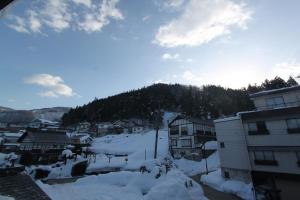 野沢野泽高山别墅酒店的一座被雪覆盖的小镇,背景是一座山