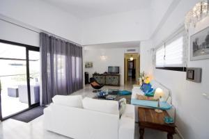 波洛普La Villa La Vie的客厅配有白色的沙发和桌子