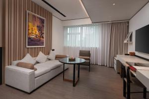 深圳THE MUMIAN HOTEL Shenzhen luohu的客厅配有沙发和桌子