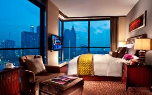 广州广州方圆奥克伍德豪景酒店公寓的酒店客房设有一张床和一个大窗户