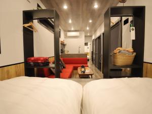IchikikushikinoFukiagehama Field Hotel的一间卧室配有一张床和一张红色的沙发