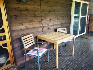 塔姆沃思Peaceful cabin in a rural setting 2km from CBD的门廊上的一张木桌和两把椅子