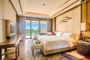 三亚三亚海棠湾天房洲际度假酒店（海底餐厅）的一间卧室配有一张床、一张书桌和一台电视
