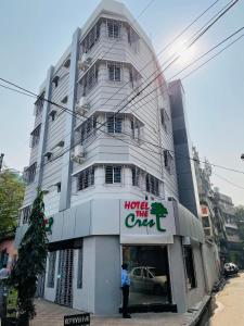 加尔各答Hotel The Crest的站在酒店前面的建筑物前的人