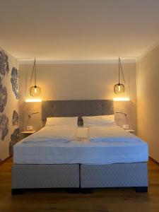 乌尔姆Safranberg Hotel & Sauna的一间卧室配有一张带两个灯的床