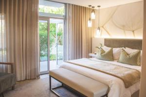 温特和克The Windhoek Luxury Suites的一间卧室设有一张大床和一个大窗户