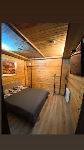 VasylʼkivБабай Садиба的木制客房内的一间卧室,配有一张床