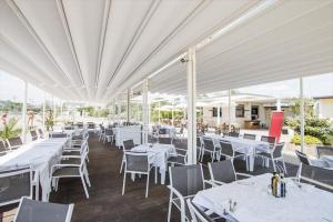 切塞纳蒂科切塞纳蒂科大酒店的一间白色天篷下带白色桌椅的餐厅