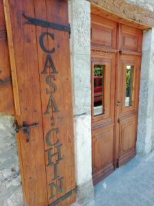 贝特伦Casa Rural "Casa Chin", Val d'Aran的通往建筑物的木门,上面有标志