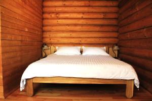 瓦杜伊泽Pensiunea Ioana的卧室配有木墙内的一张床