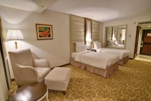 卡拉奇卡拉奇明珠大陆酒店的酒店客房,配有两张床和椅子