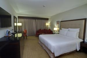 卡拉奇卡拉奇明珠大陆酒店的酒店客房设有一张白色大床和一张沙发。