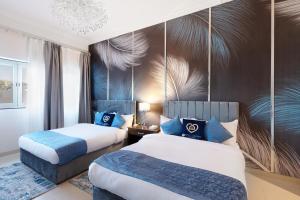 迪拜Exclusive Escapes Private Pool Homes and Villas by GLOBALSTAY Holiday Homes的酒店客房 - 带两张带蓝色枕头的床