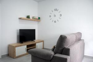 贝赫尔-德拉弗龙特拉Apartamento Calma的客厅配有椅子和墙上的时钟