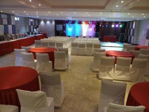 阿格拉Hotel Rudra Vilas的一间设有红色和白色桌子及白色椅子的房间