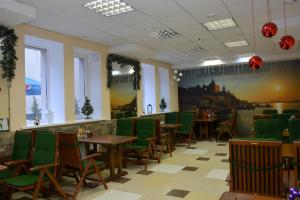 尼古拉耶夫卡拉维拉酒店的用餐室配有桌子和绿色椅子