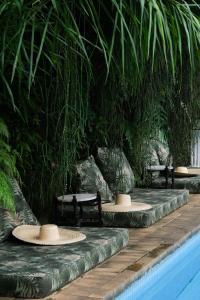 里约热内卢Mama Ruisa Boutique Hotel的池边一排桌子和长椅