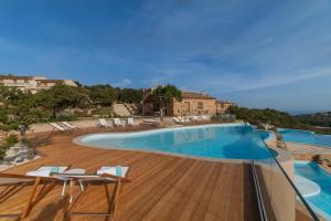 阿尔扎凯纳Hotel Borgo Smeraldo的一个带椅子和木制甲板的大型游泳池