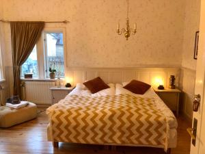 VäddöPensionat Kanalvillan的一间卧室设有一张床、一个窗户和一个吊灯。