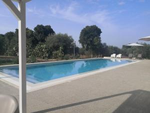 基亚拉蒙泰-古尔菲Dimora di Dante的游泳池旁设有两把白色椅子