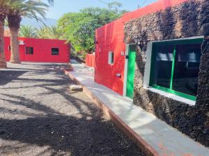 弗龙特拉Pensión Casa Trudo的靠近墙壁的红绿色建筑