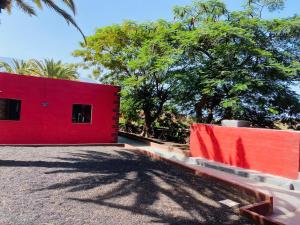 弗龙特拉Pensión Casa Trudo的红色的建筑,有红墙和树木