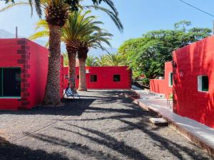 弗龙特拉Pensión Casa Trudo的一座红色的建筑,前面有棕榈树