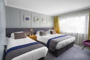 邓多克邓多克皇家酒店的酒店客房设有两张床和窗户。