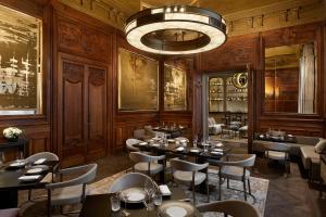 巴黎Maison Villeroy的一间带桌椅和吊灯的餐厅