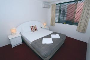 黄金海岸圣特罗佩度假酒店的一间卧室配有一张床,上面有两条毛巾