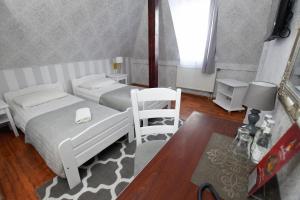 Rymanów朵尔奥斯图亚酒店的一间卧室配有两张床和椅子