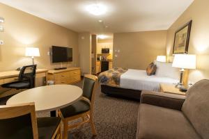 麦克默里堡BC敏思 - 麦克默里堡 - 如斯提汽车旅馆的酒店客房配有床、沙发和桌子。