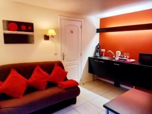 拉罗什-阿登Hebergement confort Comfortlogies La Fontanella的客厅配有棕色沙发和红色枕头