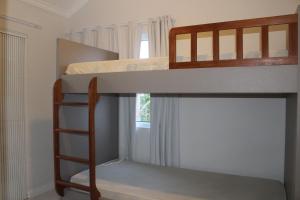 邦比尼亚斯Praia de Quatro Ilhas a 50 metros do mar的一间卧室设有两张双层床和梯子