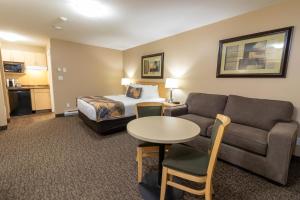 麦克默里堡BC敏思 - 麦克默里堡 - 如斯提汽车旅馆的酒店客房配有床、沙发和桌子。
