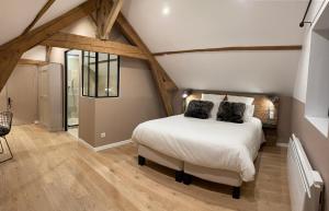 AumontL'Atelier des Magnolias的卧室配有白色的床和木地板