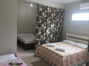 弗洛里亚诺波利斯Loft - Aeroporto的小房间设有两张床和窗帘