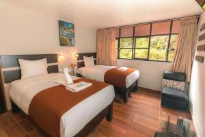 马丘比丘马丘比丘萨曼纳奇旅舍的酒店客房设有两张床和窗户。
