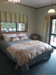 HaruruRural Palms的卧室配有带枕头的床铺和窗户。
