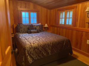 林肯市Whistling Winds Motel的卧室配有木墙和窗户。