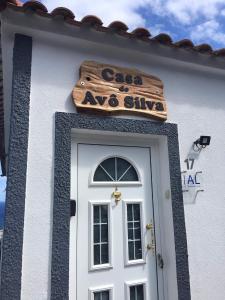 圣克鲁什达什弗洛里什Casa do Avô Silva的白色的建筑,上面有门和标志