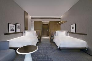 深圳深圳国际会展中心皇冠假日酒店的酒店客房,设有两张床和一张沙发