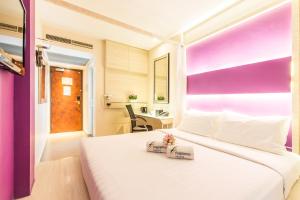 新加坡Fragrance Hotel - Viva的一间卧室配有一张白色大床,其中装有2盒