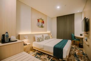 GlagahCordia Hotel Yogyakarta - Hotel Dalam Bandara的酒店客房,配有床和电视
