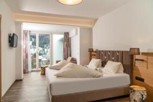 拉姆绍达赫斯坦Aktivhotel Pehab的卧室设有一张白色大床和一扇窗户。