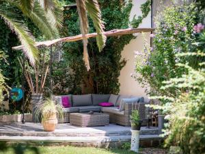 纳博讷Chambre d'Hôtes Villa Ambrosia的一个带蓝色沙发的庭院,并种植了植物