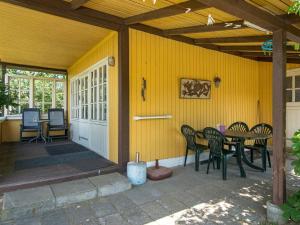 诺德堡4 person holiday home in Nordborg的黄色的房屋设有带桌椅的庭院